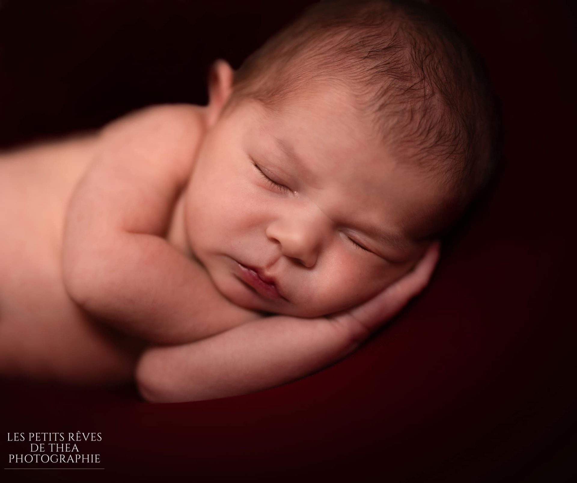 bébé qui dort sur fond rouge et noir