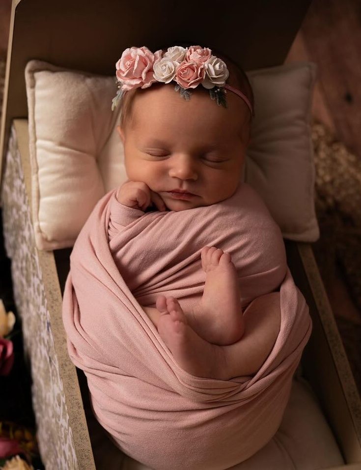 bébé dans un lit avec ornement de fleur
