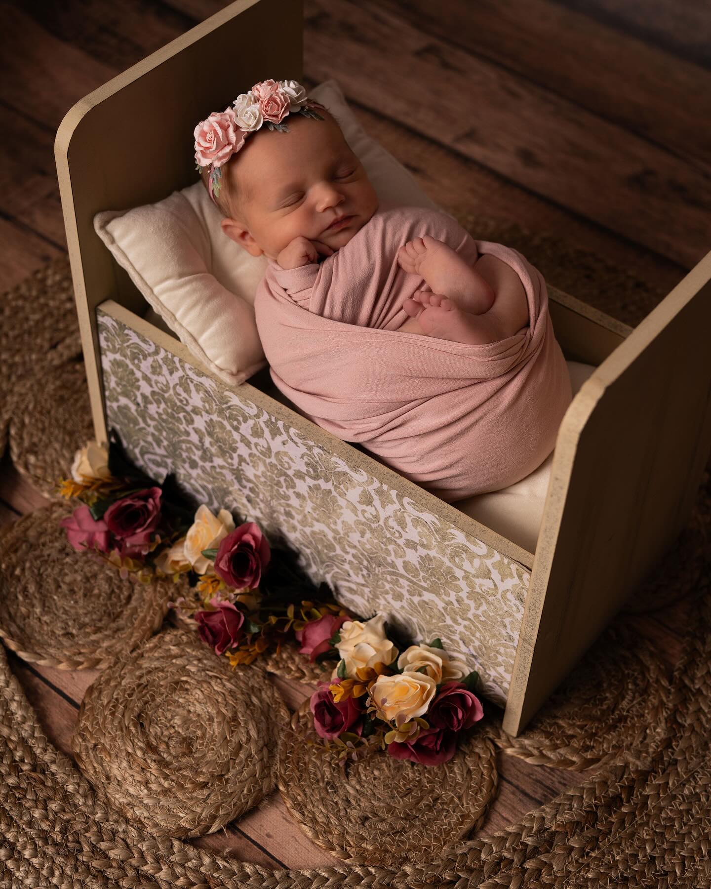 bébé dans un lit entouré de fleurs