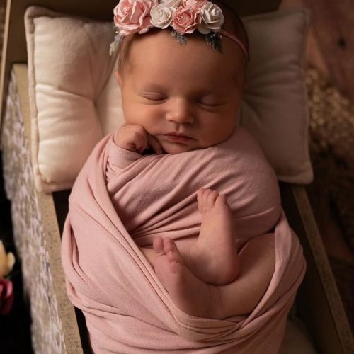 bébé dans un lit avec ornement de fleur
